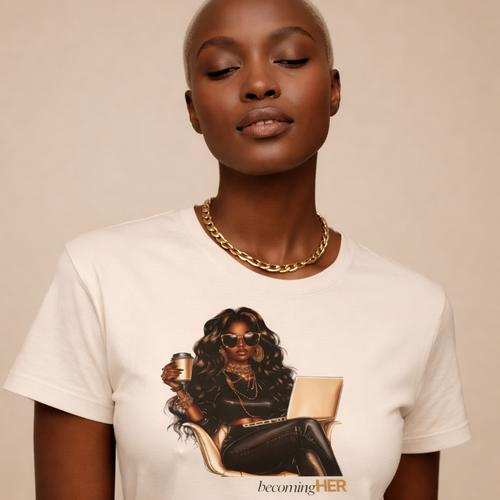 Model styling a beige Becoming HER graphic t-shirt with a gold chain necklace.